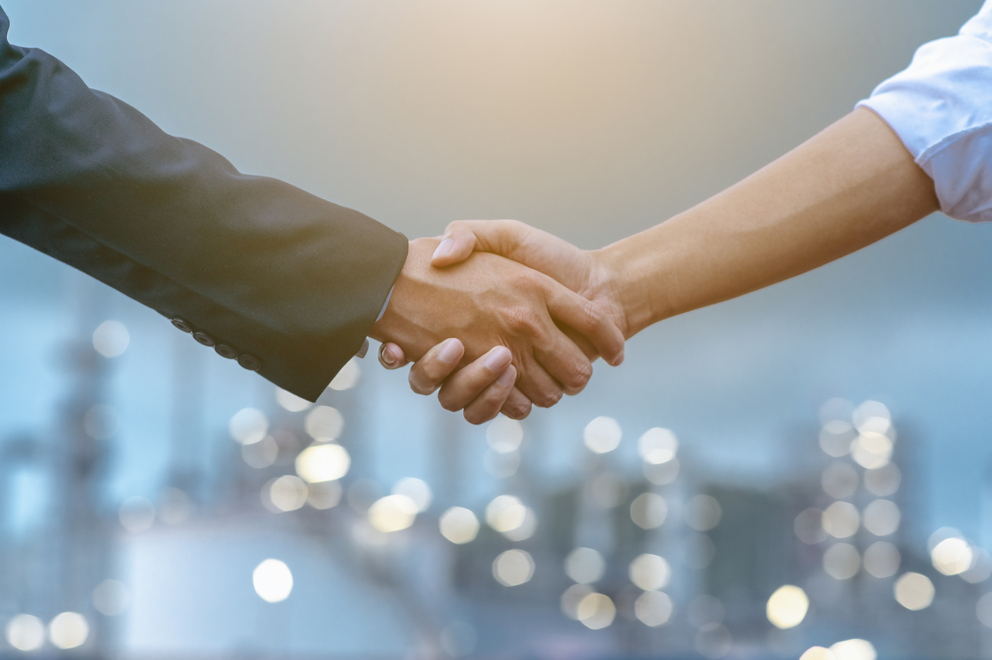 Close-up of two business partners standing and shaking hands they greeting each other during a meeting hand together is a collaborative concept of teamwork for business partners.